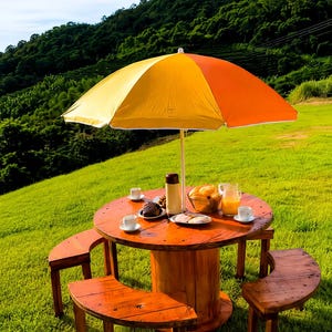 May include: A round wooden table with three matching curved benches, topped by a large yellow and orange umbrella. The table holds a brown thermos, a glass pitcher of orange juice, two white cups, and plates containing various baked goods.