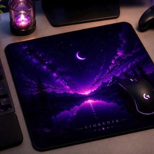 Peut inclure: Tapis de souris rectangulaire noir avec un paysage violet et noir représentant un croissant de lune, des nuages et un plan d'eau. Une souris et un clavier noirs sont également visibles.