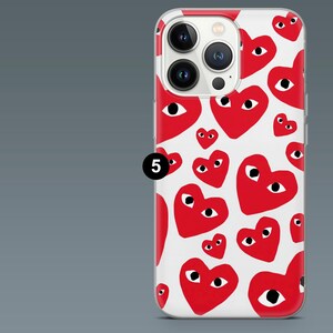 May include: A clear phone case featuring a pattern of red hearts with black eyes on a white background. The case has a camera cutout and a black number 5 in a circle.