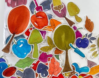 May include: A collection of die-cut stickers featuring watercolor illustrations of autumn-themed items including pumpkins, mushrooms, leaves, and fruits in various colors. The stickers are displayed in front of a clear plastic bag labeled Fall Original Art.