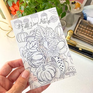 May include: A clear plastic sleeve containing a collection of black and white die-cut stickers featuring autumn-themed illustrations of pumpkins, acorns, various leaves, and mushrooms, with the text Fall Live Art Stickers printed at the top.