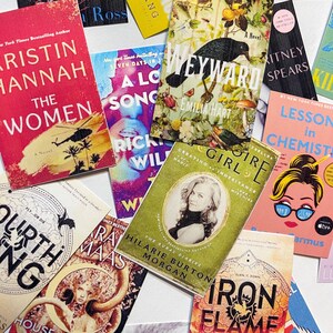 May include: A collection of paperback books with colorful covers. The titles include "The Women", "A Long Song", "Weyward", "Girl,  Inheritance", "Lesson in Chemistry", "Fourth Ring", "Iron Flame", and "The Rural Diaries".