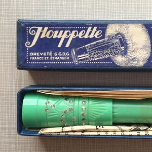 May include: Vintage turquoise powder puff applicator in its original blue box. The box is labeled "Houppette Pili" with French text. The applicator is decorated with rhinestones and is displayed with its original packaging.