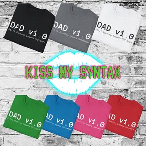 May include: Seven t-shirts in black, grey, white, green, blue, pink, and red. Each shirt features the white text DAD v1.0 Still Running Legacy Hardware. The centre of the image displays the neon green and pink text KISS MY SYNTAX.