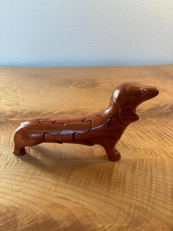 A handcrafted interlocking 3D wooden dachshund that disassembles into a puzzle — folk art, desk toy, and brain teaser all in one.