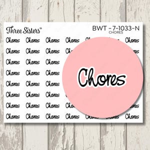 May include: A sheet of white planner stickers featuring the word Chores in a black cursive font. The text Three Sisters and the code BWT-7-1033-N CHORES are printed at the top. A large pink circle partially covers the sticker sheet.