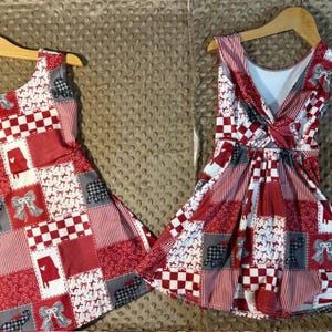 May include: Two sleeveless dresses featuring a patchwork pattern of red, white, and gray squares. The prints include bows, checkered patterns, and silhouettes of the state of Alabama. One dress has a simple scoop neckline, while the other features a twisted knot detail at the back.