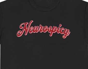 May include: Black t-shirt with the word "Neurospicy" in a red, cursive font with a white outline. The shirt is made of a soft material and has short sleeves.
