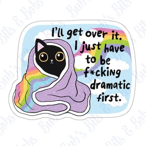 May include: A black cat wrapped in a rainbow and purple blanket with the text "I'll get over it. I just have to be f*cking dramatic first."