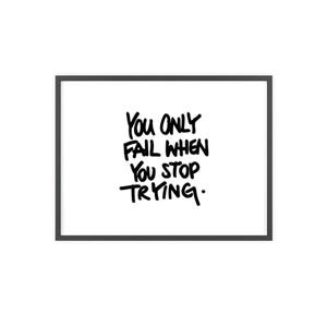 Könnte beinhalten: Ein rechteckiges Wandbild mit einem dünnen schwarzen Rahmen um einen weißen Hintergrund. In der Mitte befindet sich der schwarze handschriftliche Text: You Only Fail When You Stop Trying. Die Schrift ist in einem fetten, lockeren Stil gehalten.