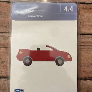 May include: A red convertible car die cut on a white background. The package reads "4x4" and "convertible". The brand name "QuicKutz" is visible. The packaging states the die cuts and embosses.