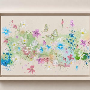 Könnte beinhalten: Gerahmtes Gemälde einer Blumenszene mit einer Vielzahl von Blumen und Schmetterlingen. Das Kunstwerk zeigt rosa, blaue, weiße und lila Blumen mit grünem Laub vor einem neutralen Hintergrund. Das Gemälde ist in einem weißen Rahmen eingefasst.