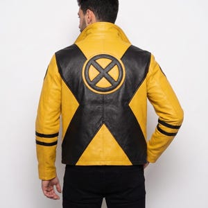 May include: A yellow and black leather jacket featuring a large circular X-Men logo on the back. The jacket has a high collar, long sleeves with two horizontal black stripes on each forearm, and a prominent black X-shaped panel across the back.