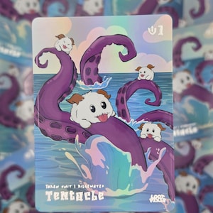 May include: A rectangular holographic trading card featuring a cartoon illustration of purple tentacles emerging from blue ocean water. Four small, white, fluffy creatures with brown ears and tongues sticking out are perched on the tentacles.