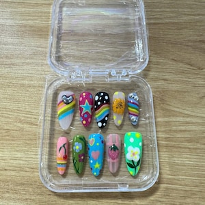 Unhas postiças arco-íris do orgulho LGBTQIA+, unhas estilete coloridas com efeito degradê, unhas em formato de caixão em tons pastel, unhas para festivais, unhas com estrelas.