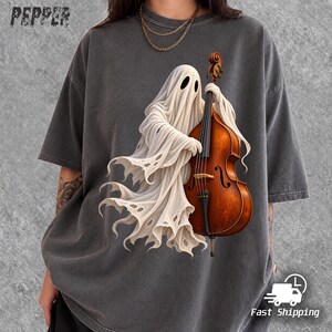 May include: A charcoal grey t-shirt featuring a graphic of a white ghost playing a brown wooden double bass. The word PEPPER is printed in the top left corner. The ghost has a tattered hem and dark oval eyes, while the instrument shows detailed wood grain and black strings.