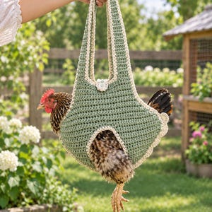 May include: A sage green crochet chicken sling carrier featuring a cream-colored border and a single button closure at the top. The carrier has a long handle and a structured pouch design with an opening for the chicken's legs and tail.