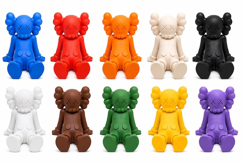 Op de afbeelding: Een verzameling van tien kleurrijke vinylfiguren in verschillende kleuren, waaronder blauw, rood, oranje, cr&egrave;me, zwart, wit, bruin, groen, geel en paars. Elke figuur heeft een kenmerkend ontwerp met gekruiste ogen en een afgeronde kop.