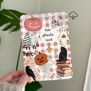 Puede incluir: Una tarjeta rectangular con un fondo de cuadros beige y blanco y un patrón de telaraña. Muestra varias ilustraciones temáticas de Halloween, incluyendo una calabaza, una calavera, fantasmas, un gato negro sobre libros, un murciélago, un cuervo y un esqueleto con cabeza de calabaza. El texto dice hot ghouls read.