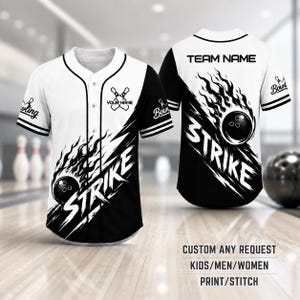 May include: A white and black button-down baseball jersey featuring a flaming bowling ball graphic and the word STRIKE in bold white letters. The front includes a small bowling pin icon with the text YOUR NAME, while the back displays TEAM NAME.