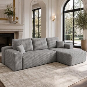 May include: A light gray sectional sofa featuring a textured corduroy-style fabric, three back cushions, and a chaise lounge section on the right side. The sofa includes two small square throw pillows in the same matching gray fabric.