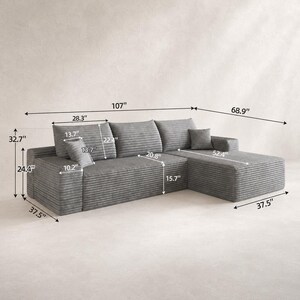 May include: A gray corduroy sectional sofa with a chaise lounge, featuring three back cushions and two small square throw pillows. The sofa measures 107 inches in total width, 68.9 inches in depth, and 32.7 inches in total height.