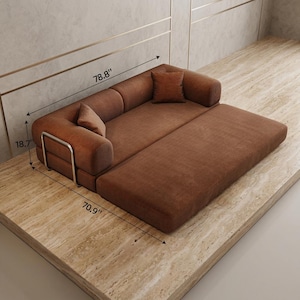 May include: A rust-colored corduroy sofa bed featuring a low-profile design, two matching square throw pillows, and a silver metal frame accent on the side. The sofa measures 78.8 inches in length, 70.9 inches in width, and 18.7 inches in height.