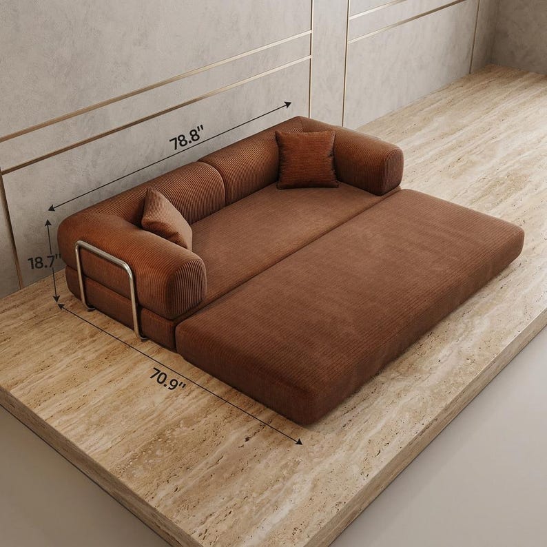May include: A rust-colored corduroy sofa bed featuring a low-profile design, two matching square throw pillows, and a silver metal frame accent on the side. The sofa measures 78.8 inches in length, 70.9 inches in width, and 18.7 inches in height.