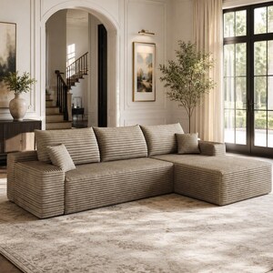 May include: A beige sectional sofa with a horizontal ribbed texture, featuring three back cushions, a chaise lounge section on the right side, and two small square throw pillows placed on the seat cushions of the sofa.