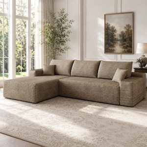 May include: A large, L-shaped sectional sofa upholstered in a textured, light brown corduroy fabric. The sofa features a chaise lounge on the left side, three wide back cushions, and two small square throw pillows in the same matching fabric.