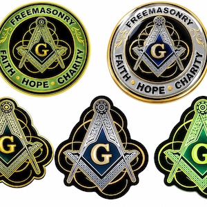 May include: Five circular and shield-shaped emblems featuring the Masonic square and compasses with a central letter G. Two round emblems display the text FREEMASONRY FAITH HOPE CHARITY. The designs incorporate black, gold, silver, and green colors.