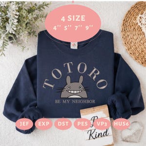 May include: A navy blue crewneck sweatshirt featuring a gray Totoro character graphic with the text TOTORO BE MY NEIGHBOR. The image includes labels for 4 sizes: 4 inches, 5 inches, 7 inches, and 9 inches, along with file formats JEF, EXP, DST, PES, VP3, and HUS6.