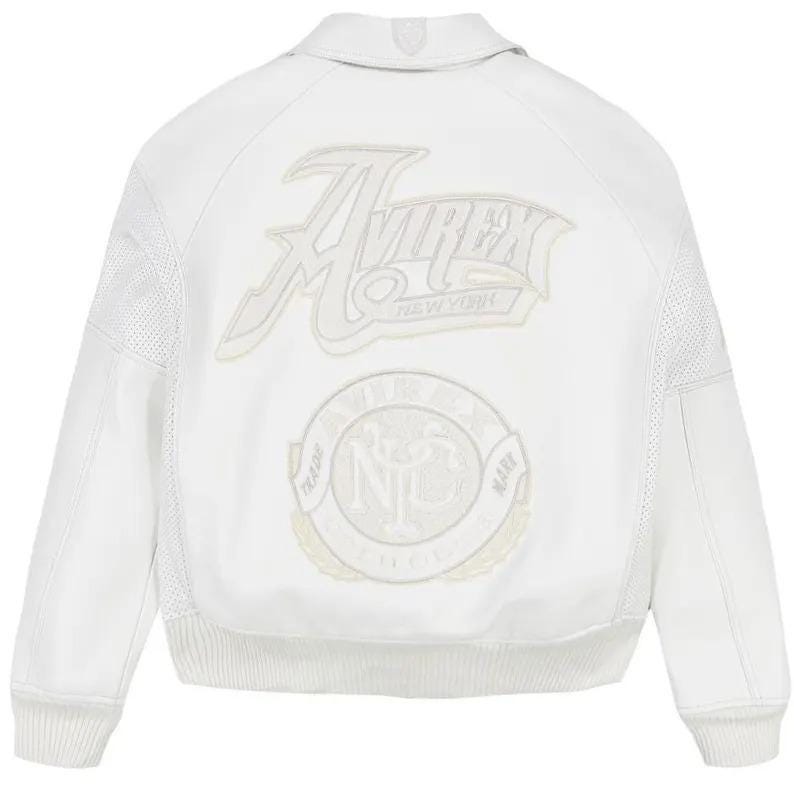 May include: A white leather bomber jacket featuring a large embroidered Avirex New York logo on the upper back and a circular Avirex NYC trade mark patch below it. The jacket includes a collared neckline, ribbed cuffs, and perforated leather panels.