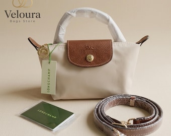 Bolsa transversal Longchamp Mini bege em nylon, com alça removível.