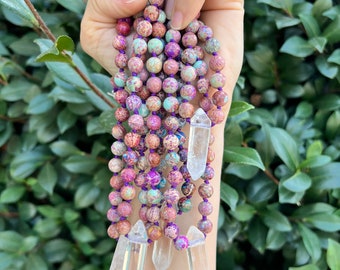 May include: A multi-strand necklace made of small, colorful, patterned beads with clear quartz crystal points hanging from the bottom.