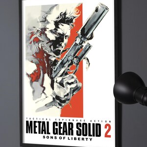 Puede incluir: Un póster enmarcado que presenta una ilustración estilizada de un personaje sosteniendo una pistola con silenciador. La obra utiliza colores negro, blanco y rojo. El texto dice: TACTICAL ESPIONAGE ACTION METAL GEAR SOLID 2 SONS OF LIBERTY.