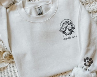 May include: White crewneck sweatshirt with a doodle mom graphic and a paw print with the name Cooper on the sleeve.
