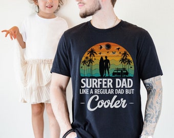 Può includere: T-shirt nera con una grafica di tramonto vintage e il testo "Surfer Dad Like a Regular Dad But Cooler".