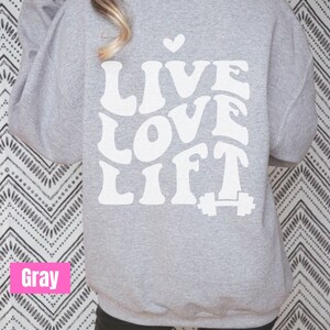 May include: Grey sweatshirt with the text "LIVE LOVE LIFT" in white with a small heart above the text and a white dumbbell below the text.