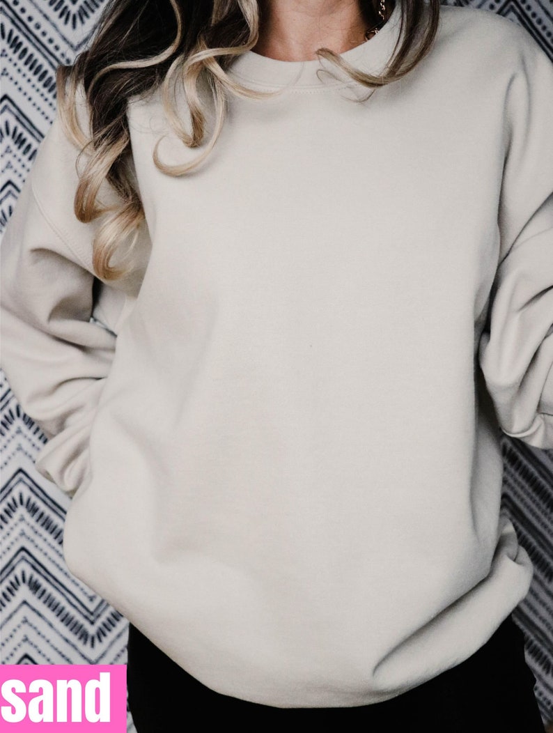 Puede incluir: Una sudadera de color arena con mangas largas y cuello redondo.