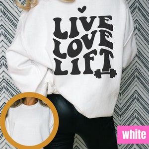 May include: White sweatshirt with black text that reads "Live Love Lift" with a small heart above the word "Live" and a dumbbell icon next to the word "Lift".