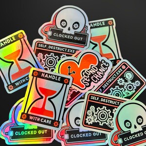 May include: A collection of holographic stickers featuring various designs including a skull with the text CLOCKED OUT, an hourglass with the text HANDLE WITH CARE, a heart with the text SECOND CHANCE, and a gear graphic with SELF_DESTRUCT.EXE.