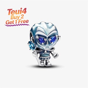 May include: A silver-toned charm bead shaped like a stylised character with blue gemstone eyes, holding a staff topped with a light blue stone. The charm features metallic blue accents on the body and head, with the text Teui4 Buy 2 Get 1 Free.