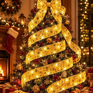 Op de afbeelding: Een versierde kerstboom met een grote gouden strik en een lint met sterrenpatroon. De boom is versierd met gouden en rode ornamenten en twinkelende lichtjes. Een open haard en een kerstsok zijn zichtbaar op de achtergrond.