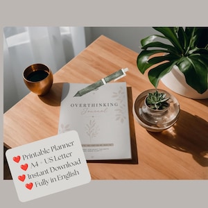 Könnte beinhalten: Ein weißes Journal mit dem aufgedruckten Text OVERTHINKING Journal auf dem Einband und einem grünen Stift mit Muster darauf. Eine weiße Karte mit dem Text Printable Planner, A4 + US Letter, Instant Download, Fully in English ist zu sehen.