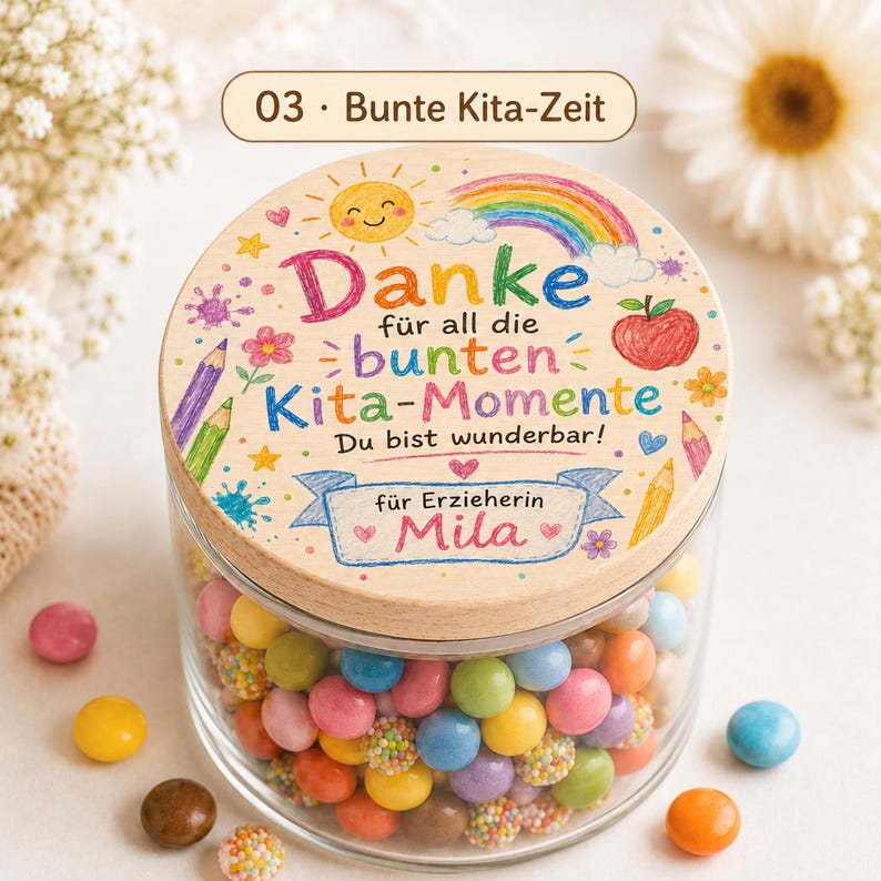 Puede incluir: Un frasco de vidrio transparente lleno de dulces coloridos, con una tapa redonda de madera decorada con ilustraciones de un arco&iacute;ris, sol, manzana y l&aacute;pices. El texto dice: 03 Bunte Kita-Zeit, Danke f&uuml;r all die bunten Kita-Momente, Du bist wunderbar, f&uuml;r Erzieherin Mila.
