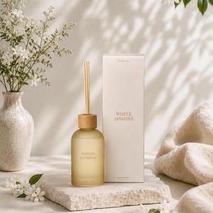 May include: A reed diffuser set featuring a frosted glass bottle with a light wood cap and a single reed, accompanied by a tall rectangular box. Both the bottle and the box are labeled with the text White Jasmine in a simple serif font.