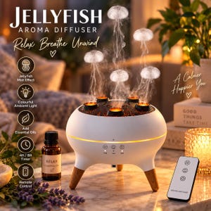 May include: A white, round aroma diffuser with three wooden legs, emitting five distinct jellyfish-shaped mist plumes from its top. The device features a control panel with icons, a small brown bottle of essential oil, and a white remote control.