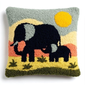 May include: A square throw pillow featuring a textured punch needle design of a large dark blue elephant and a smaller elephant calf. The scene includes a bright yellow sun, a light blue sky, peach-colored hills, and a yellow and green grassy ground.