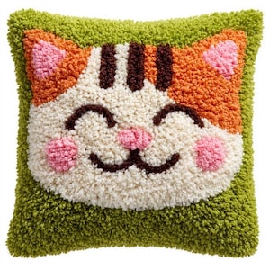 May include: A square throw pillow featuring a tufted, textured cat face design. The cat has a cream-colored face, orange ears with pink accents, dark brown stripes, and a pink nose. The background of the pillow is a solid, vibrant lime green.
